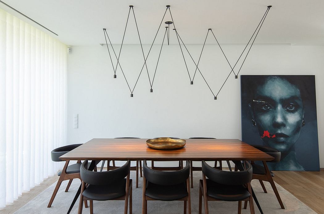 A modern, minimalist dining room with a long wooden table, black chairs, and unique lighting fixtures.