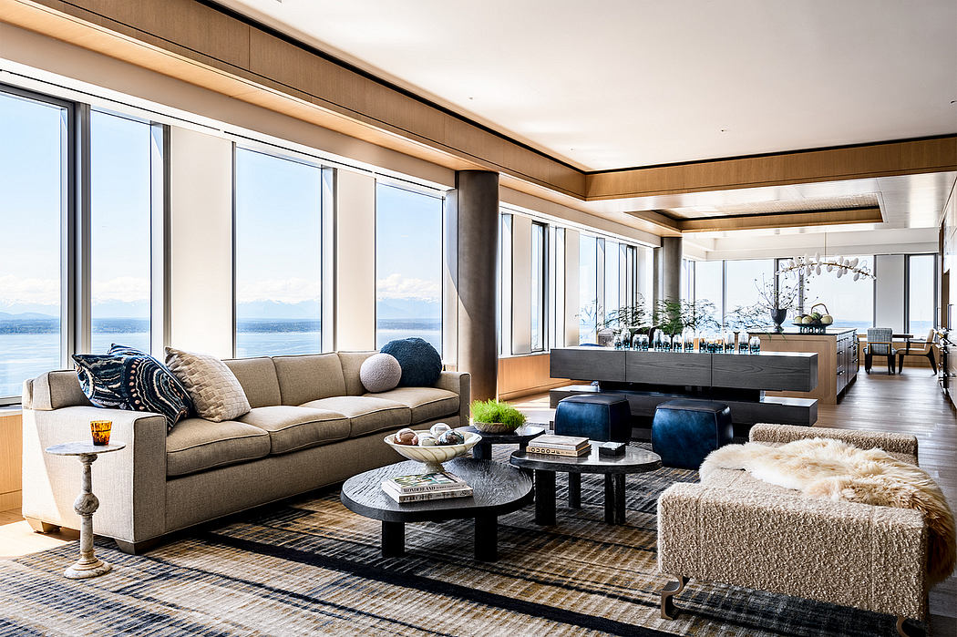 Spacious living room with panoramic windows overlooking a serene lake and mountains.