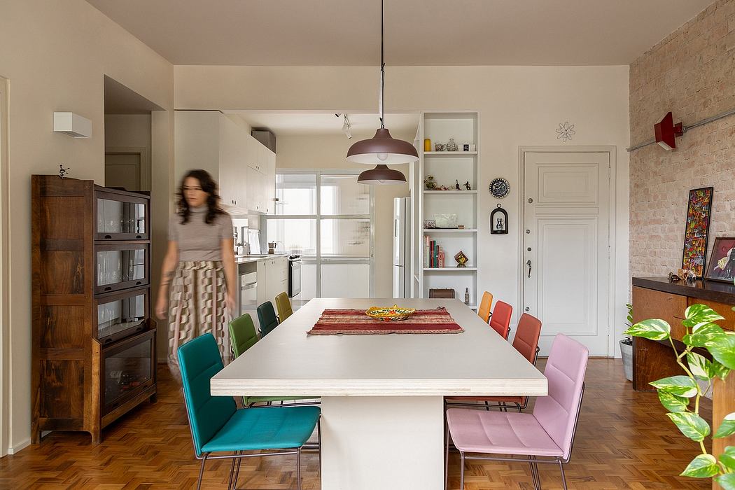 Modern dining room with colorful chairs, wooden furniture, and a striking brick wall.