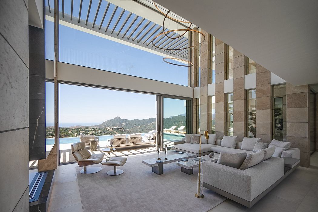 Spacious living room with large windows showcasing a scenic mountain view, featuring modern furnishings and an open, airy design.