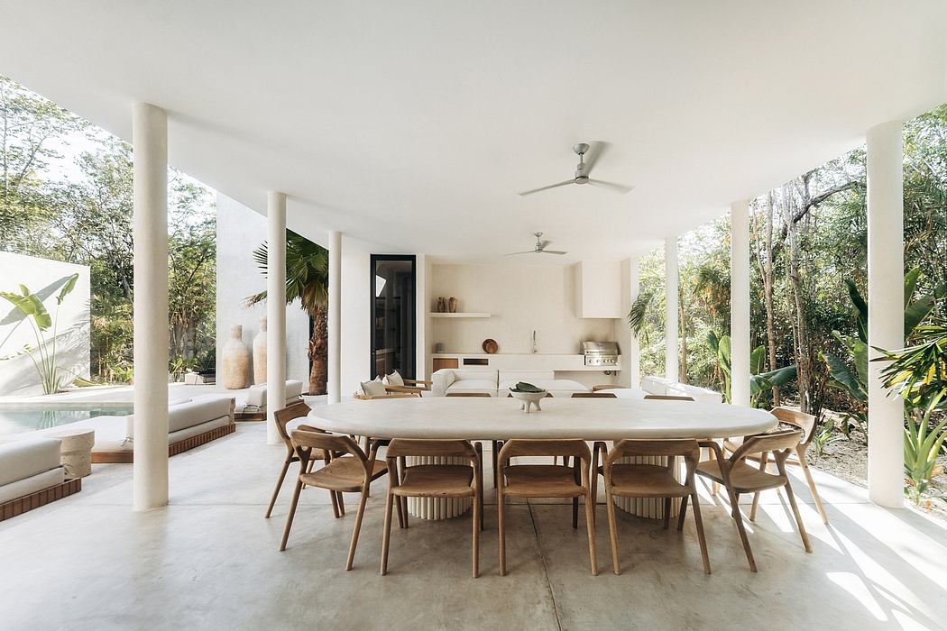 Serene outdoor dining area surrounded by lush vegetation and modern architectural elements.