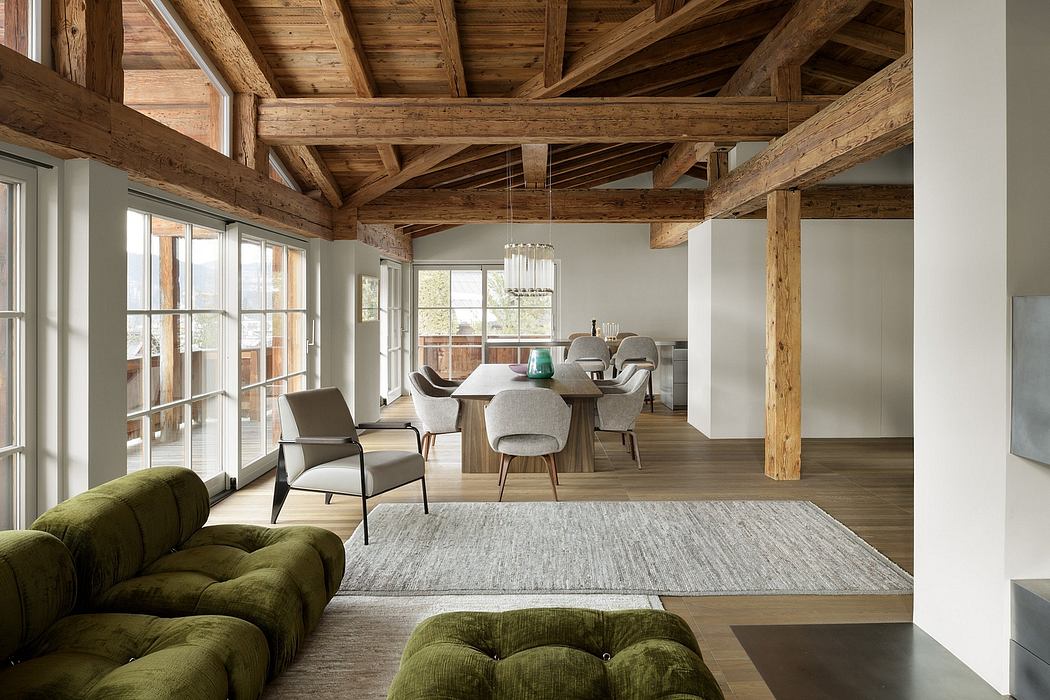 Rustic open-concept living space with exposed wooden beams, modern furnishings, and ample natural light.