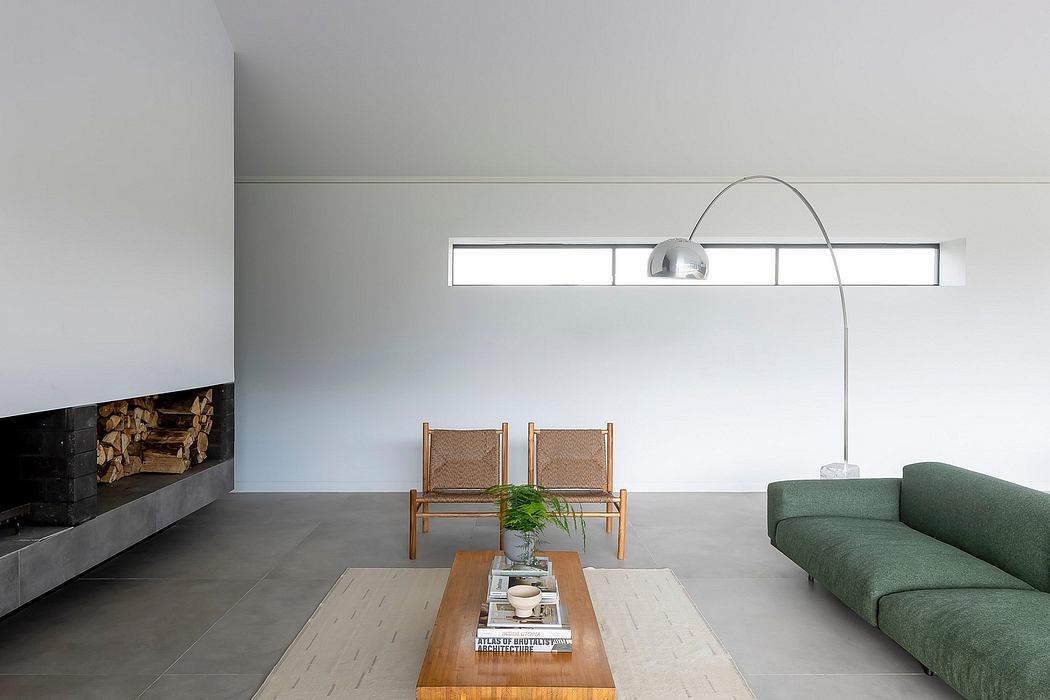 Minimalist living room with wooden chairs, potted plant, and arched floor-to-ceiling window.