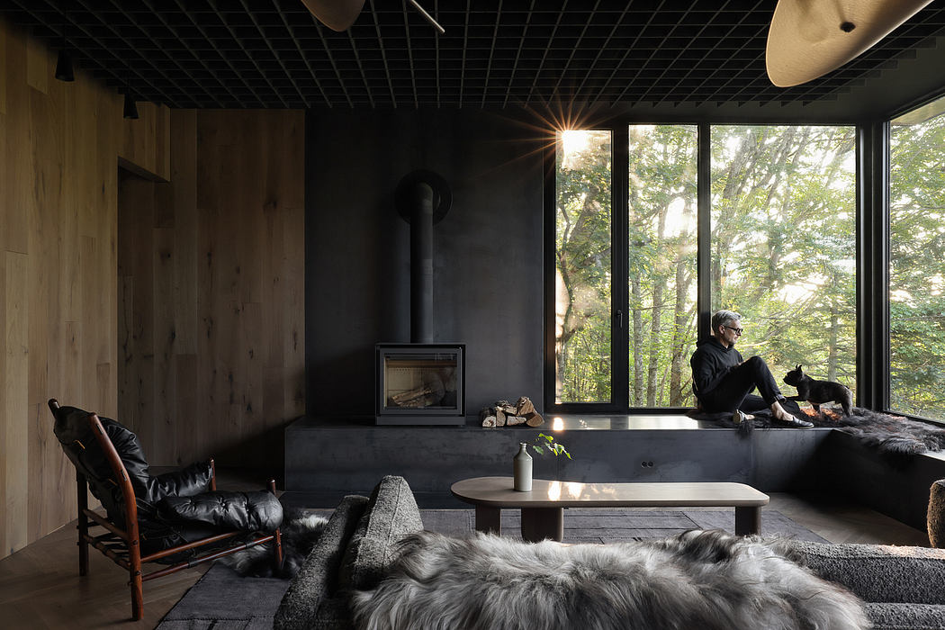 A cozy, rustic cabin interior with a large window, fireplace, and fur-covered furnishings.