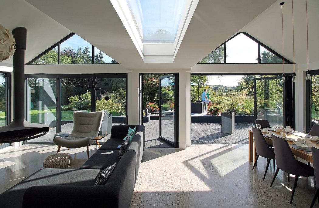 Spacious modern living room with floor-to-ceiling windows, vaulted ceiling, and outdoor view.