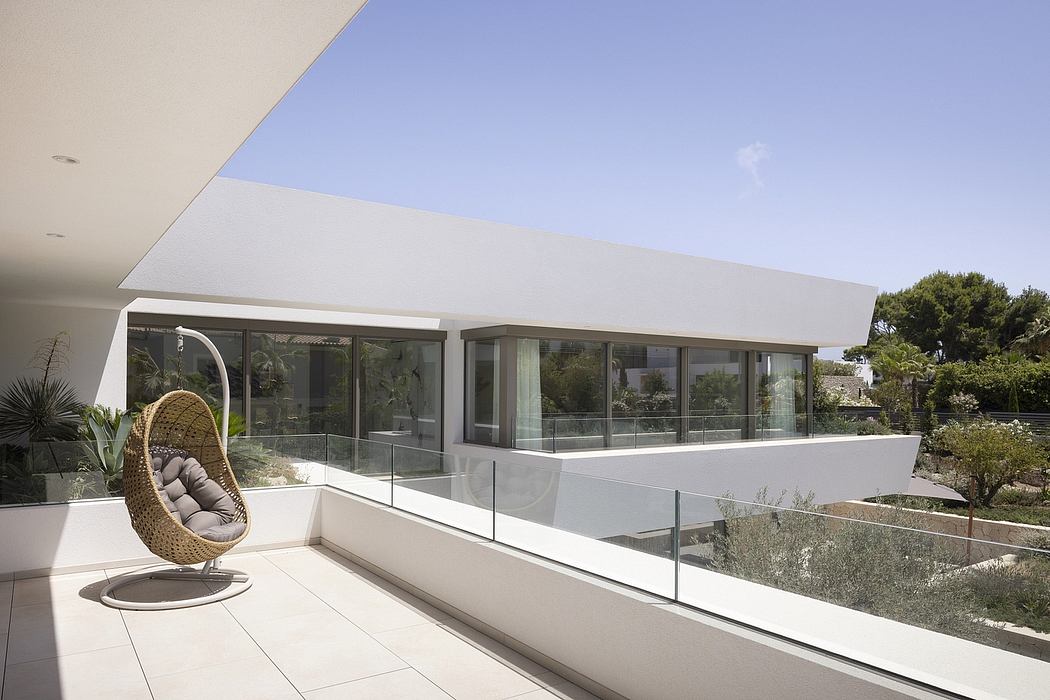 Minimalist modern home design with floor-to-ceiling glass walls and a cozy hanging chair.