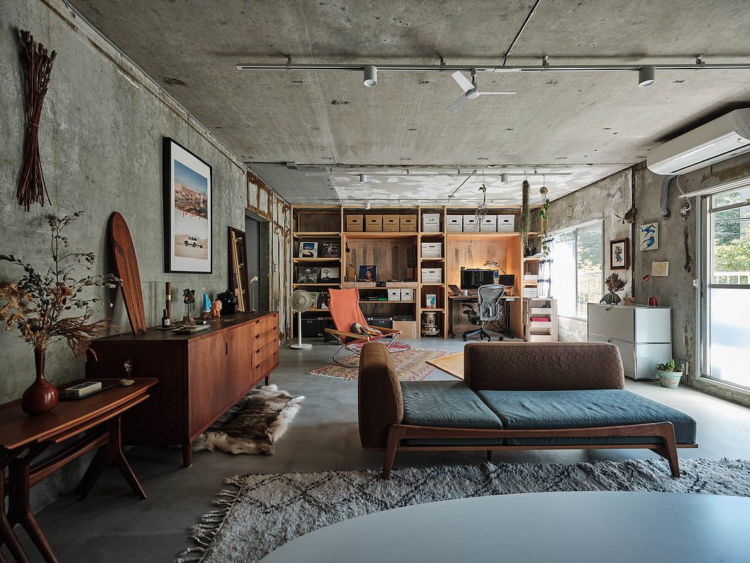 Eclectic loft-style space with concrete walls, wooden furniture, and modern decor.