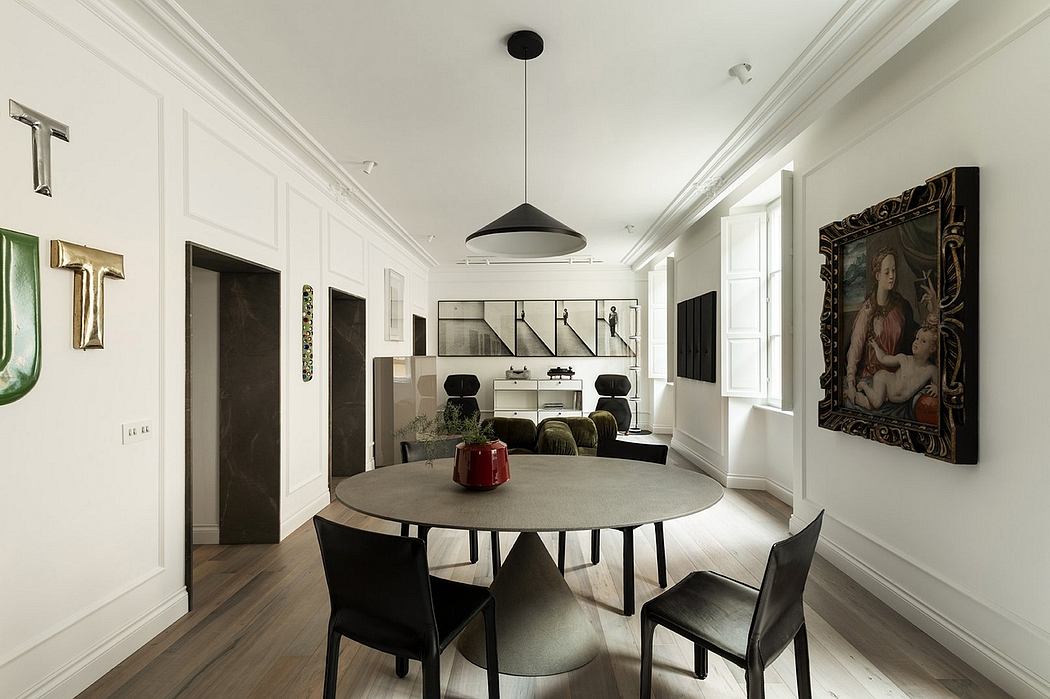 Elegant dining area with a round table, modern lighting, and classic artwork.