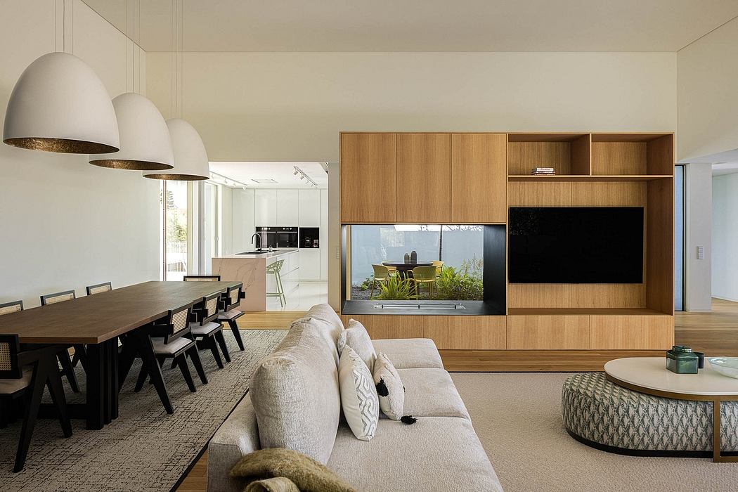 Elegant open-plan living space with modern wood cabinetry, large windows, and plush furnishings.