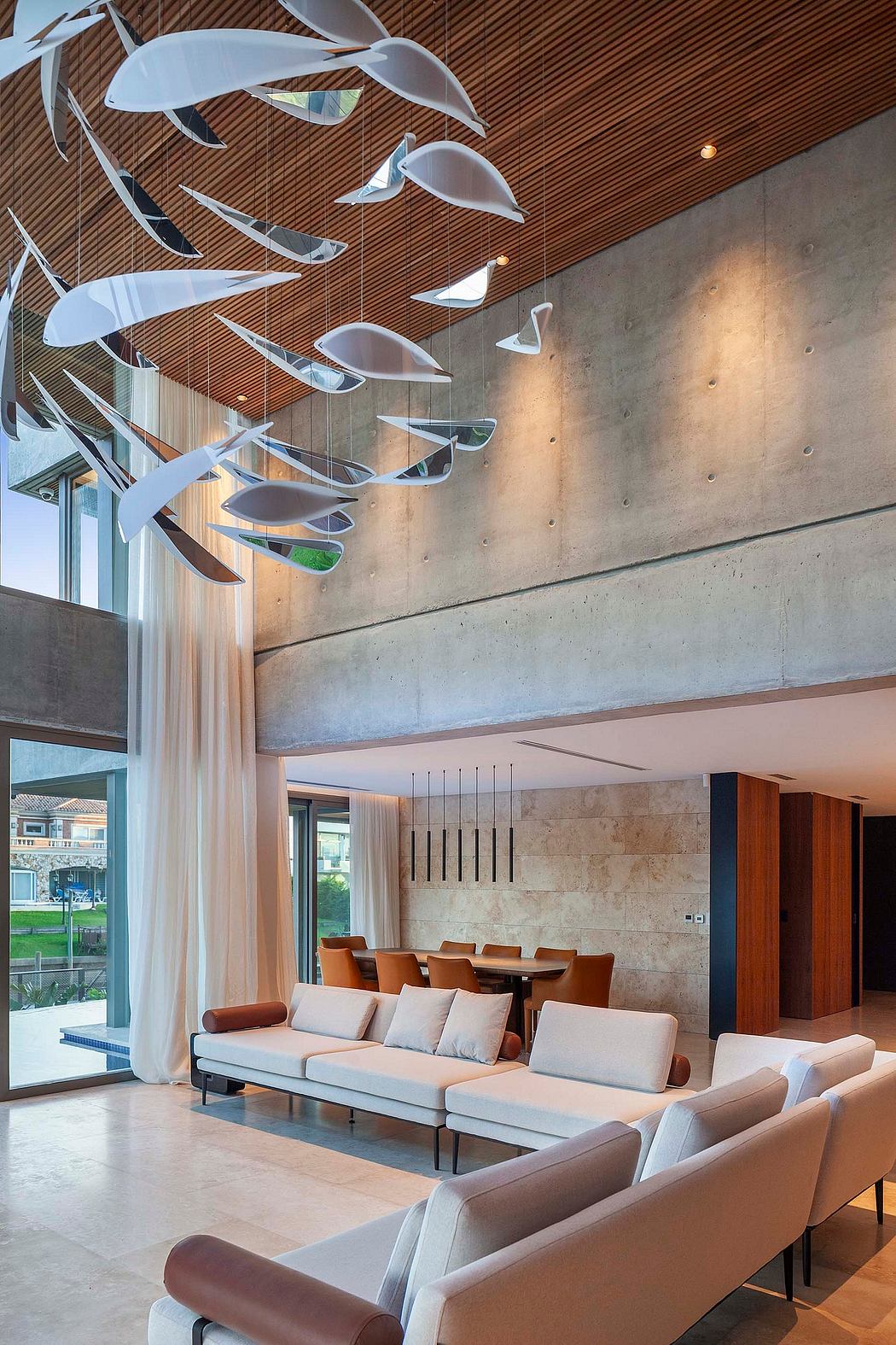Stylish modern lobby with suspended sculptural lights and concrete wall.