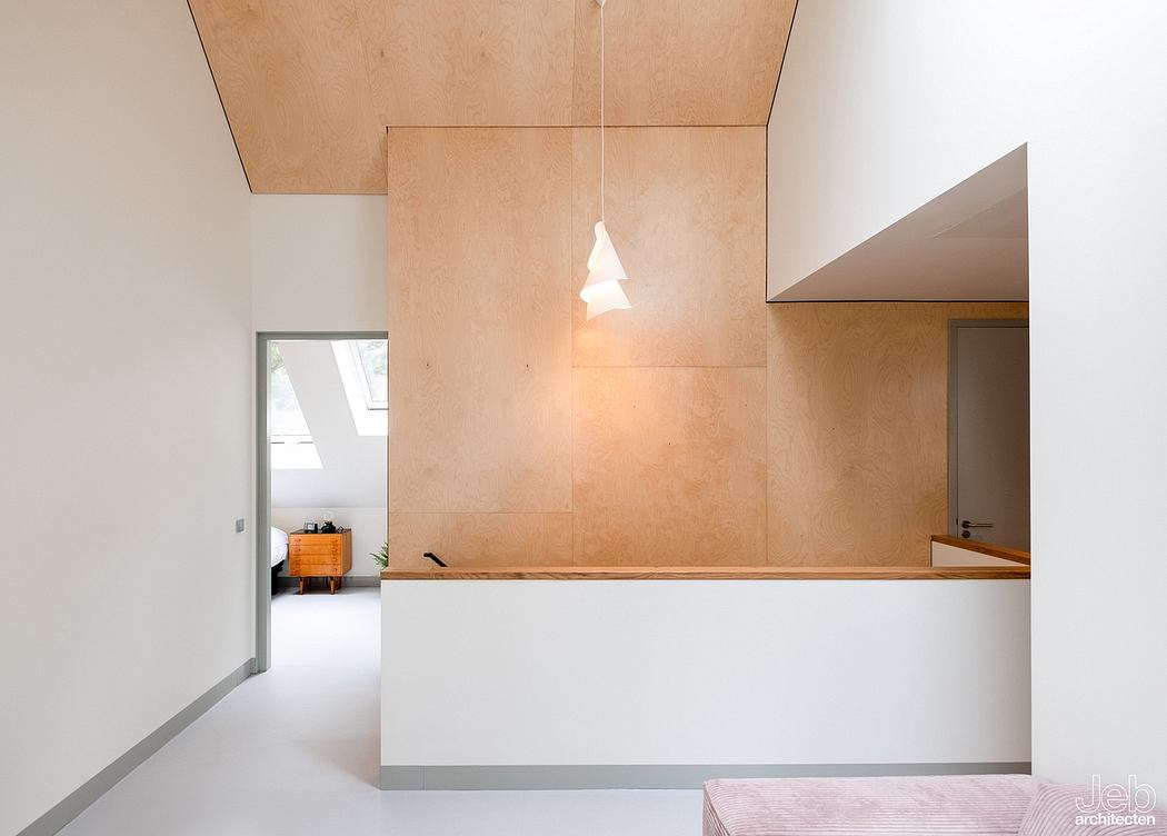 Minimalist interior with plywood paneling, pendant light, and recessed storage niche.