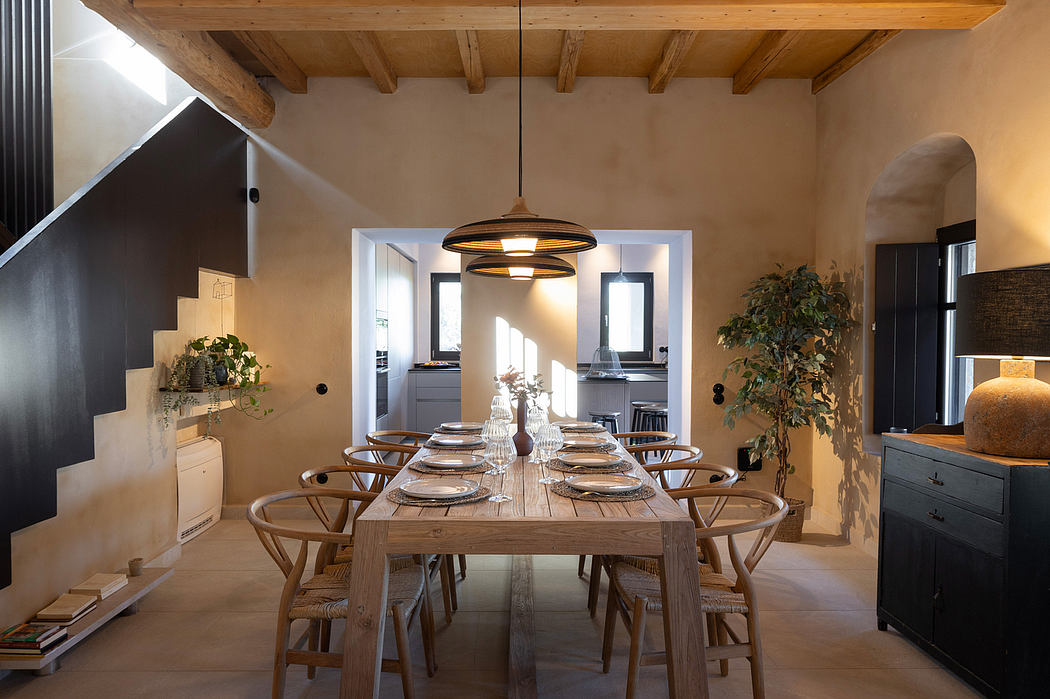 Rustic dining area with wooden beams, large dining table, and pendant lighting fixture.