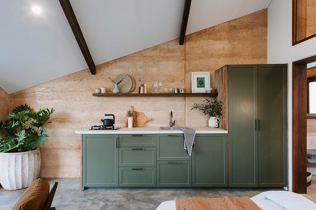 A cozy rustic kitchen with olive green cabinets, wooden beams, and a bright open layout.