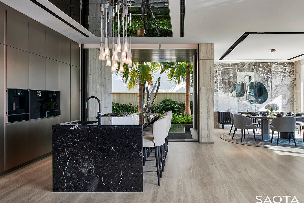 Sleek, modern kitchen with stunning marble island, lush greenery, and elegant dining area.