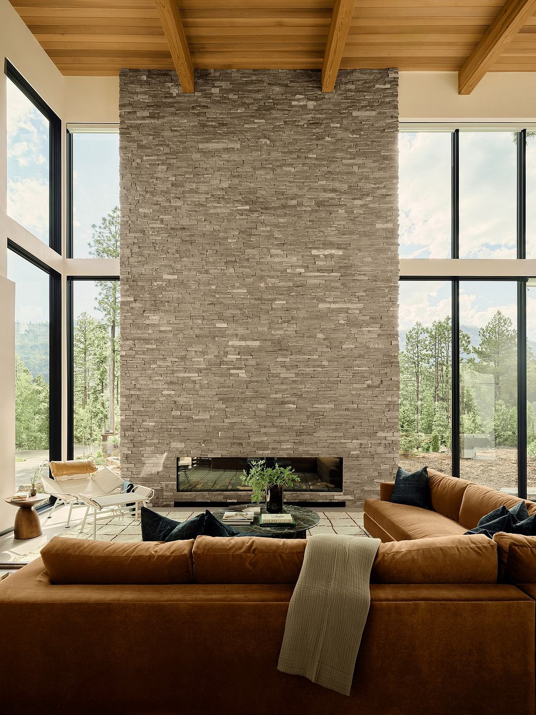 Luxurious modern living room with floor-to-ceiling stone fireplace and panoramic windows.