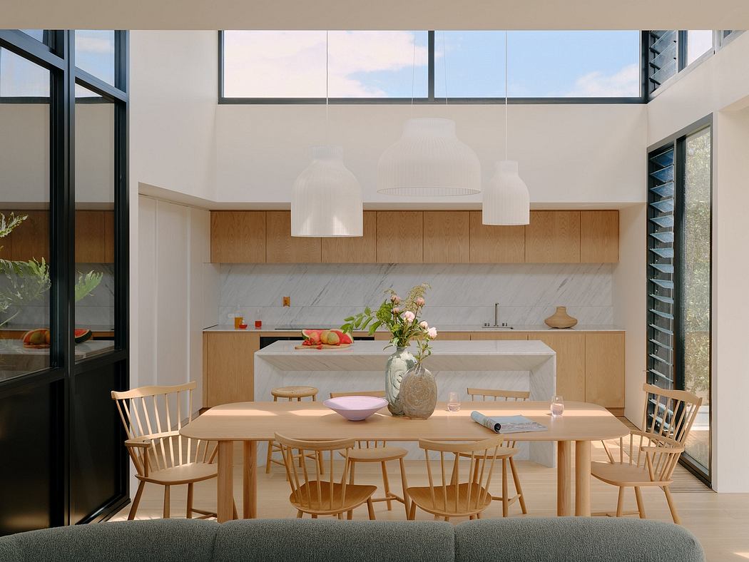 A spacious, light-filled kitchen and dining area with wood furniture and large windows.