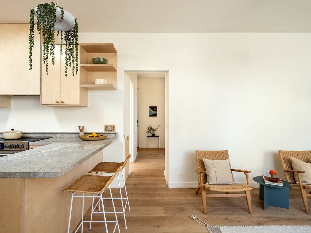 Bright, open kitchen with wood accents, hanging plants, and minimalist furnishings.