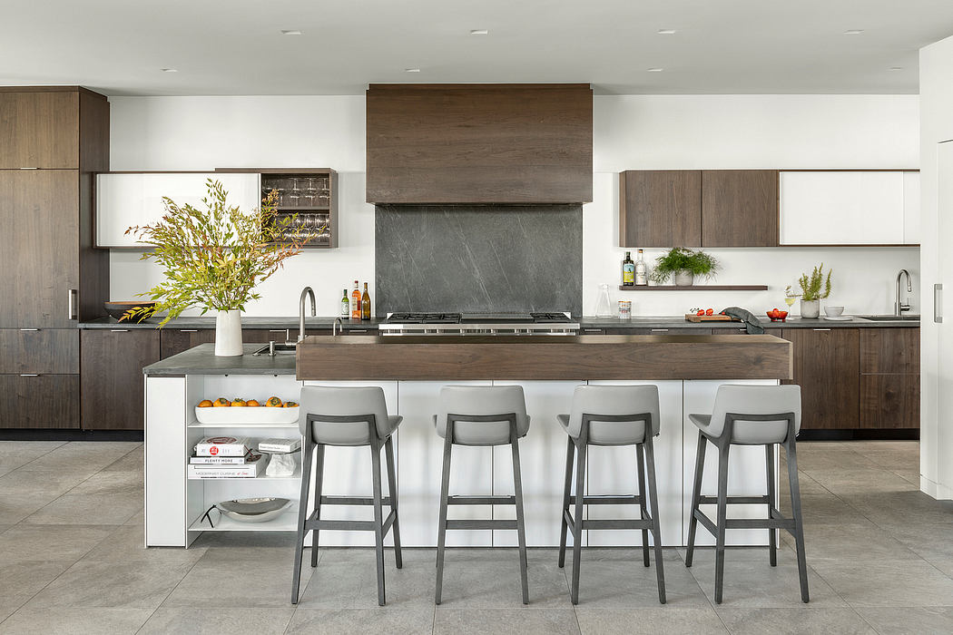 Modern kitchen with sleek wood cabinetry, large central island, and bar seating.