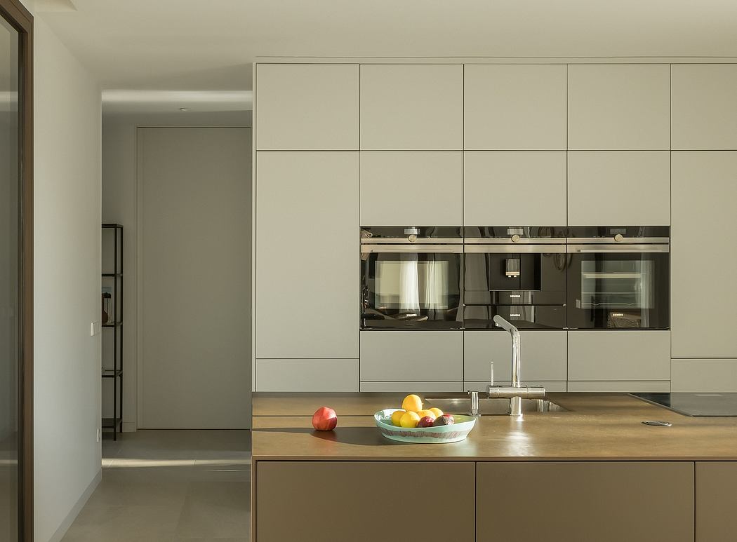 Sleek, minimalist kitchen with clean lines, built-in appliances, and a wooden countertop.