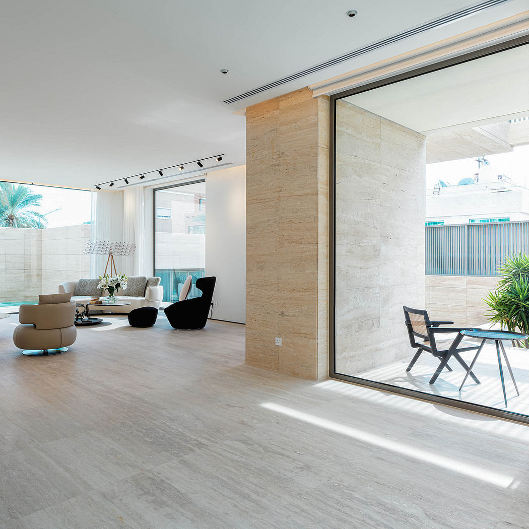 Spacious modern living room with large glass windows, wood paneling, and soft furnishings.