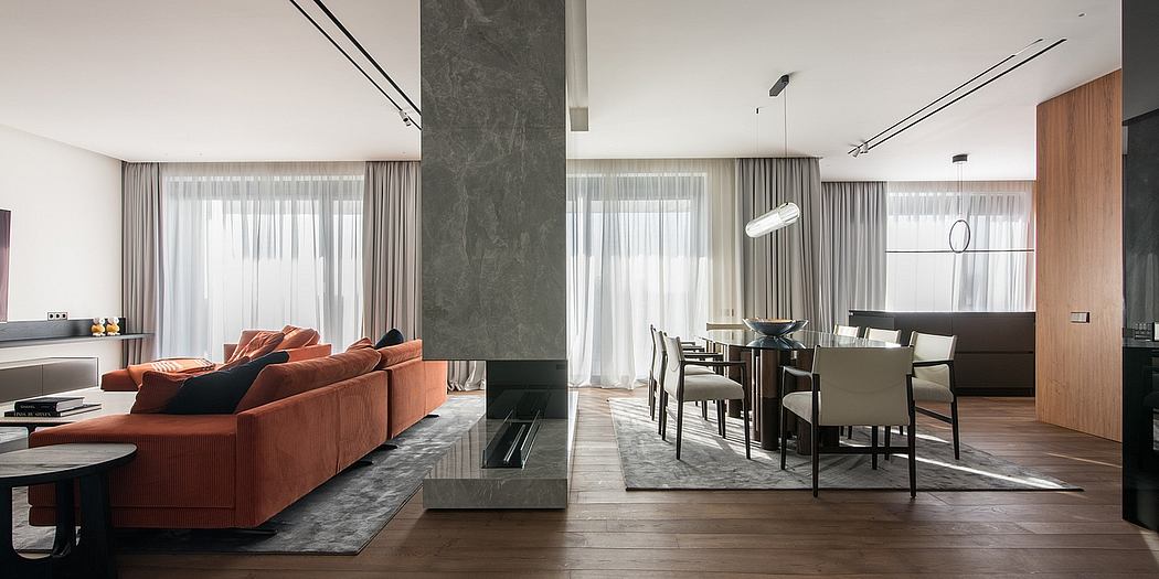 Spacious, contemporary living room with orange sofa, gray marble accent wall, and dining area.