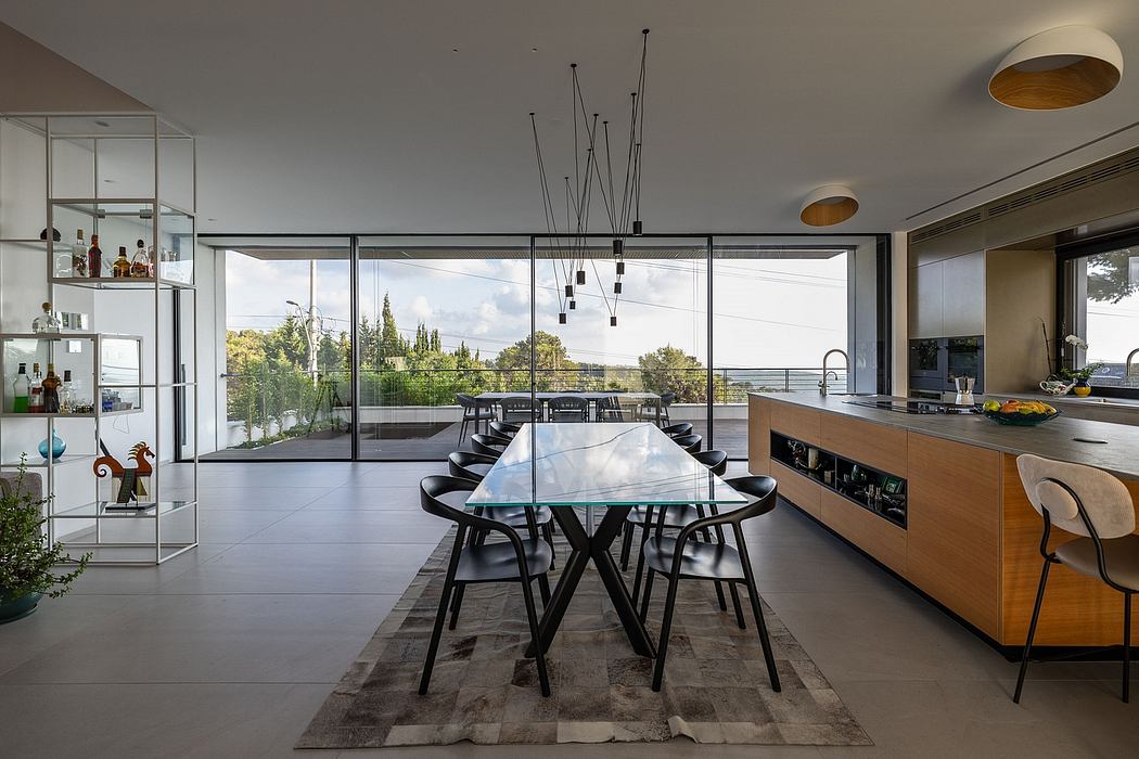 Stunning modern kitchen and dining area with sleek glass walls and contemporary lighting.
