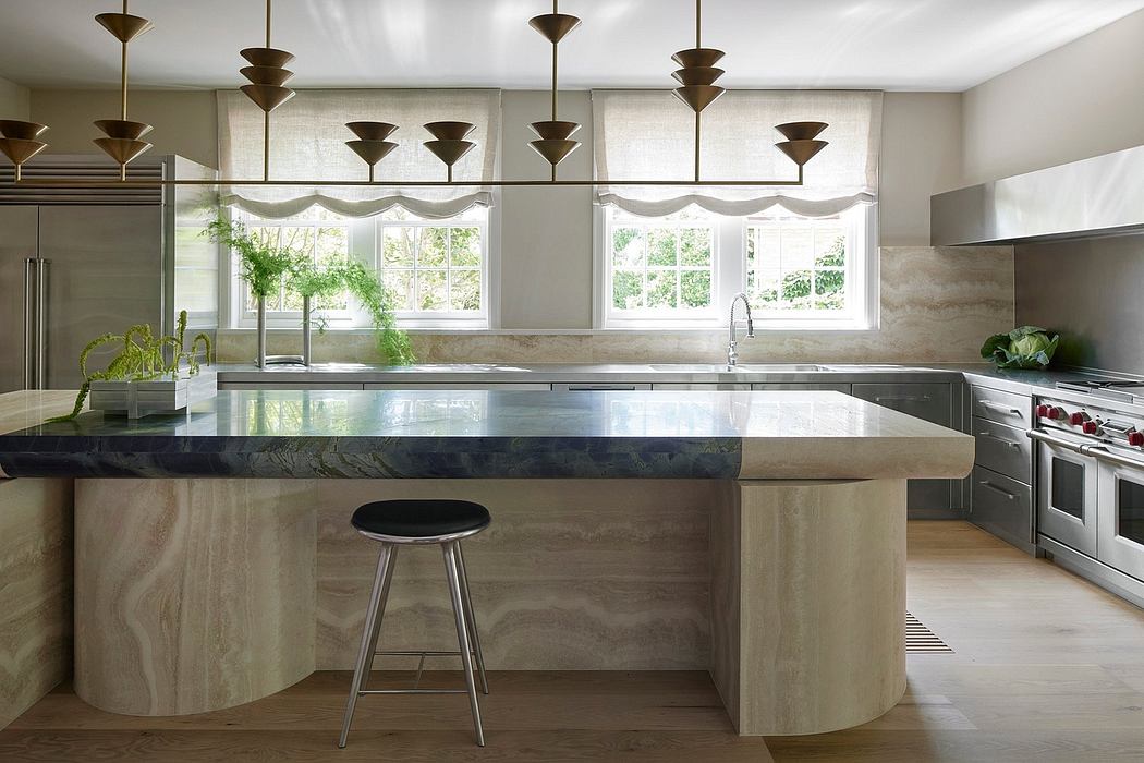 Luxurious kitchen with sleek marble counter, modern pendant lights, and large windows.