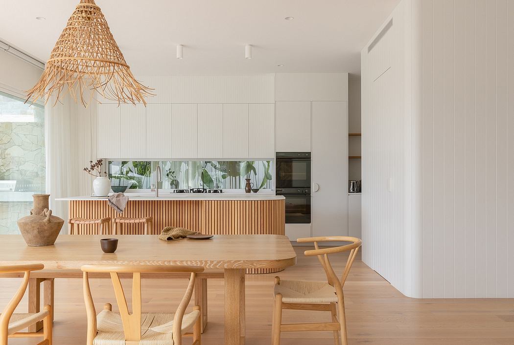 Bright, minimalist kitchen with modern wood furnishings and a striking woven pendant light.