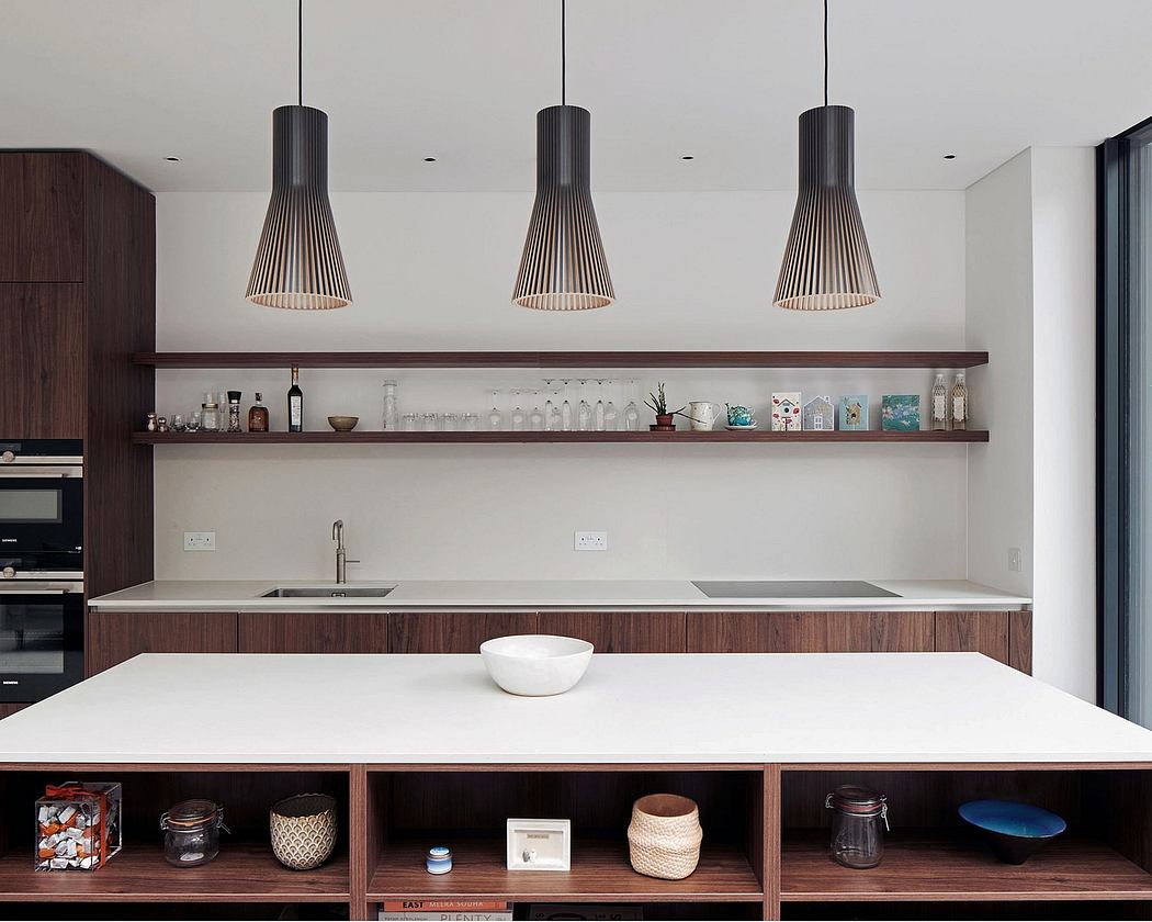 Sleek kitchen design with minimalist pendant lights, open shelving, and a white countertop.