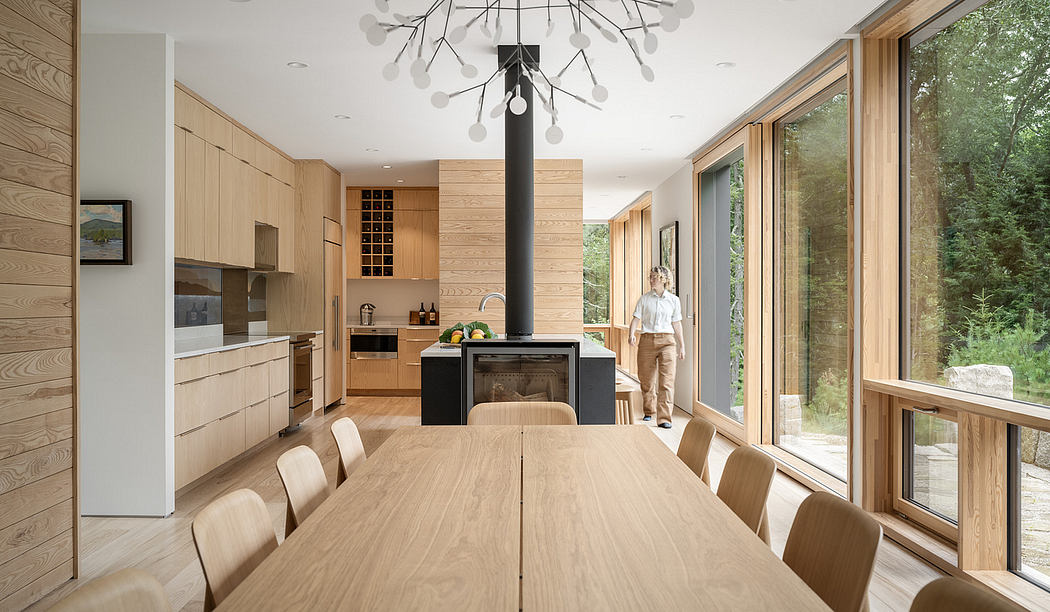 Spacious modern kitchen and dining area with sleek wood paneling and large windows.