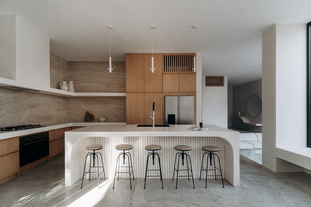 Minimalist kitchen with wooden cabinetry, white countertops, and modern bar stools.