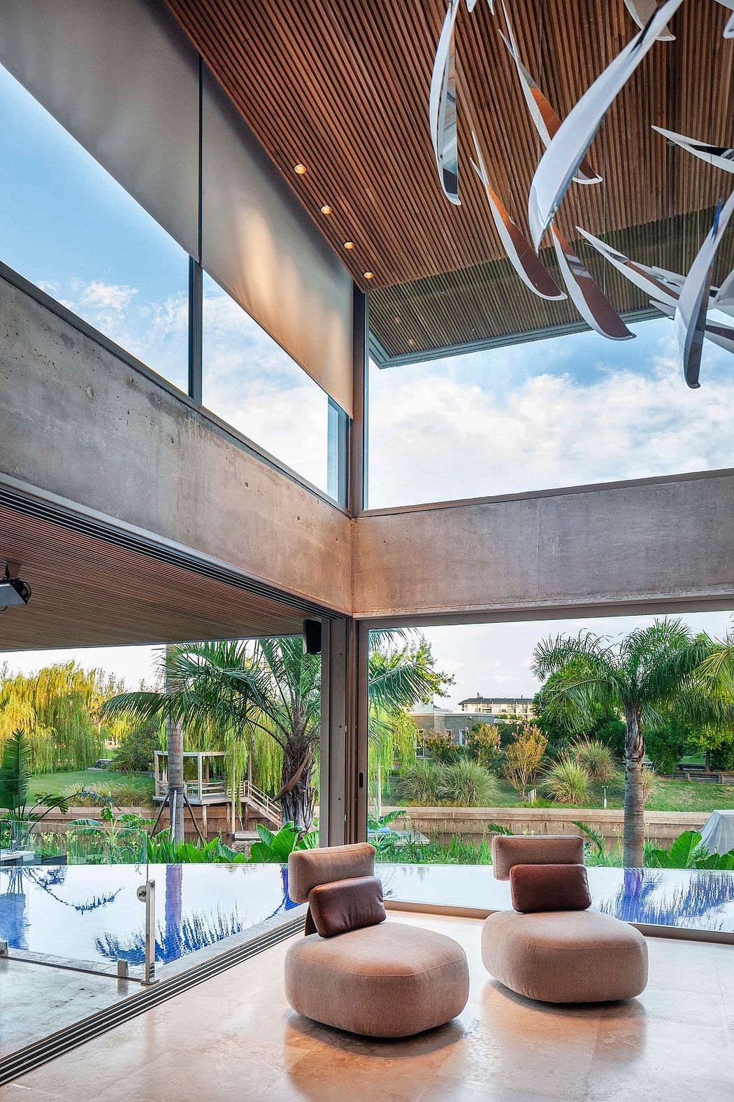 Sleek wood paneling, modern furniture, and expansive views of a lush outdoor space.