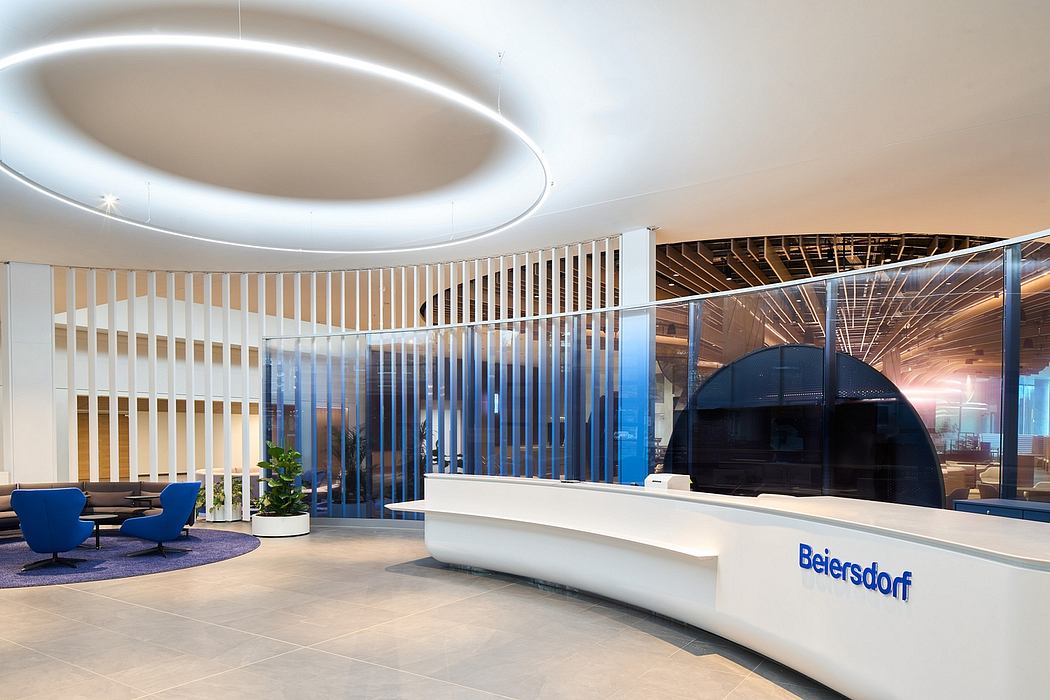 Elegant lobby with curved glass walls, modern seating, and Beiersdorf branding.
