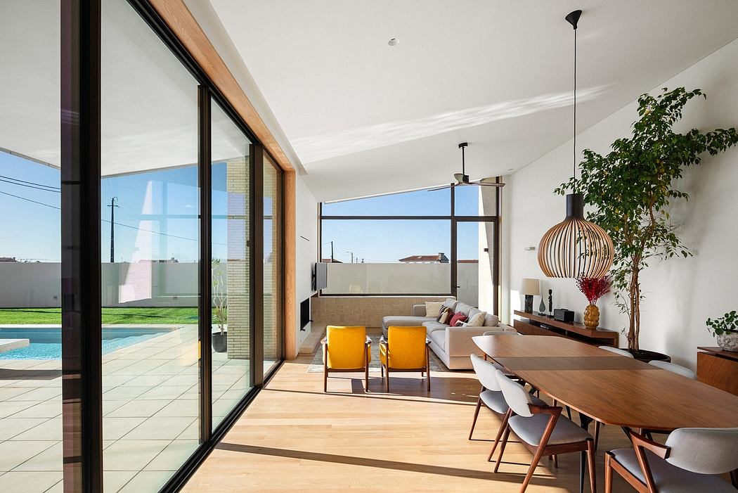 Sleek modern home with floor-to-ceiling glass walls, open-concept living space, and pool.