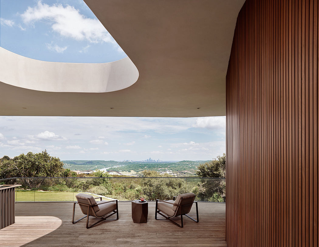 Dramatic indoor-outdoor living space with sweeping views, curved roof, and modern furnishings.