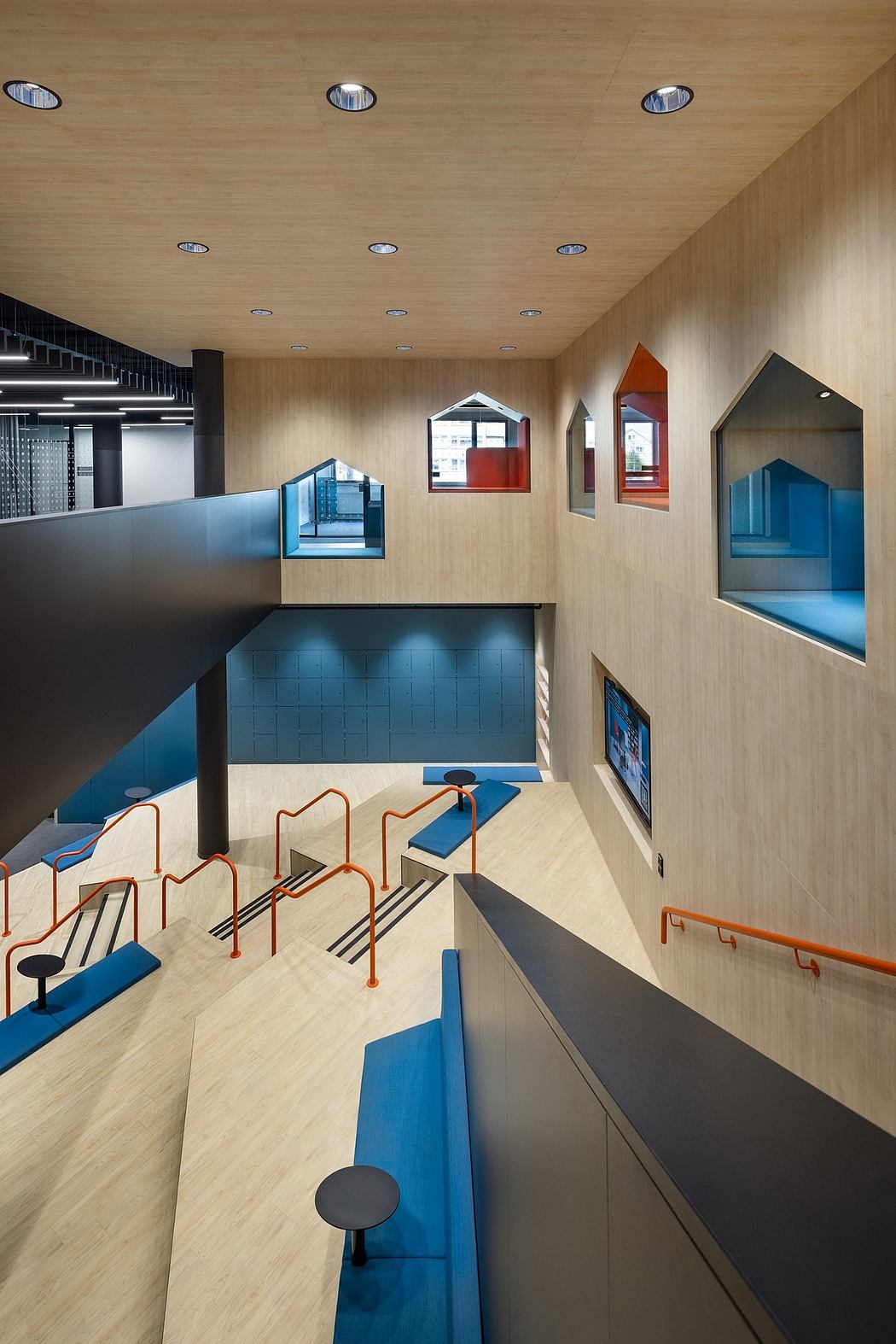 Modernist interior with geometric shapes, recessed lighting, and colorful seating arrangements.