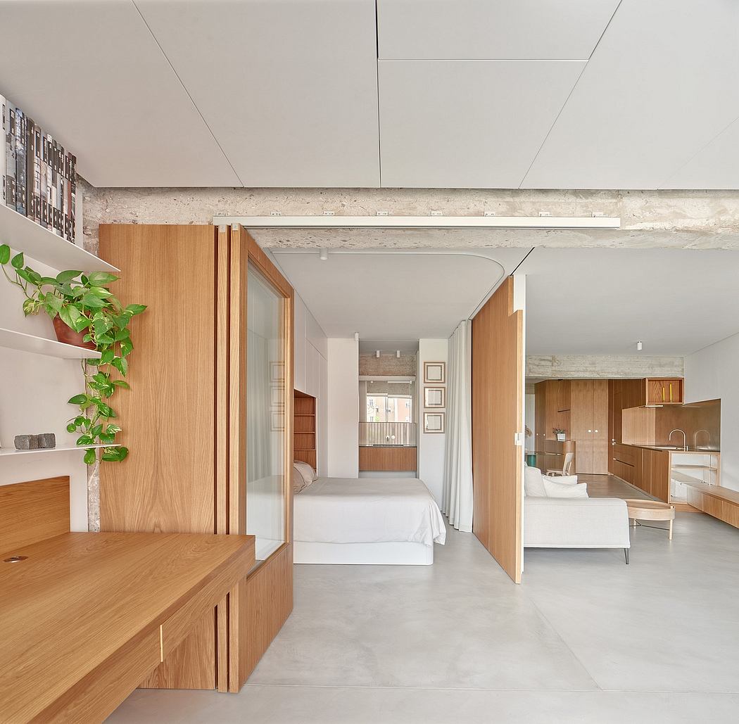 Spacious open-concept studio with clean lines, warm wood accents, and lush greenery.