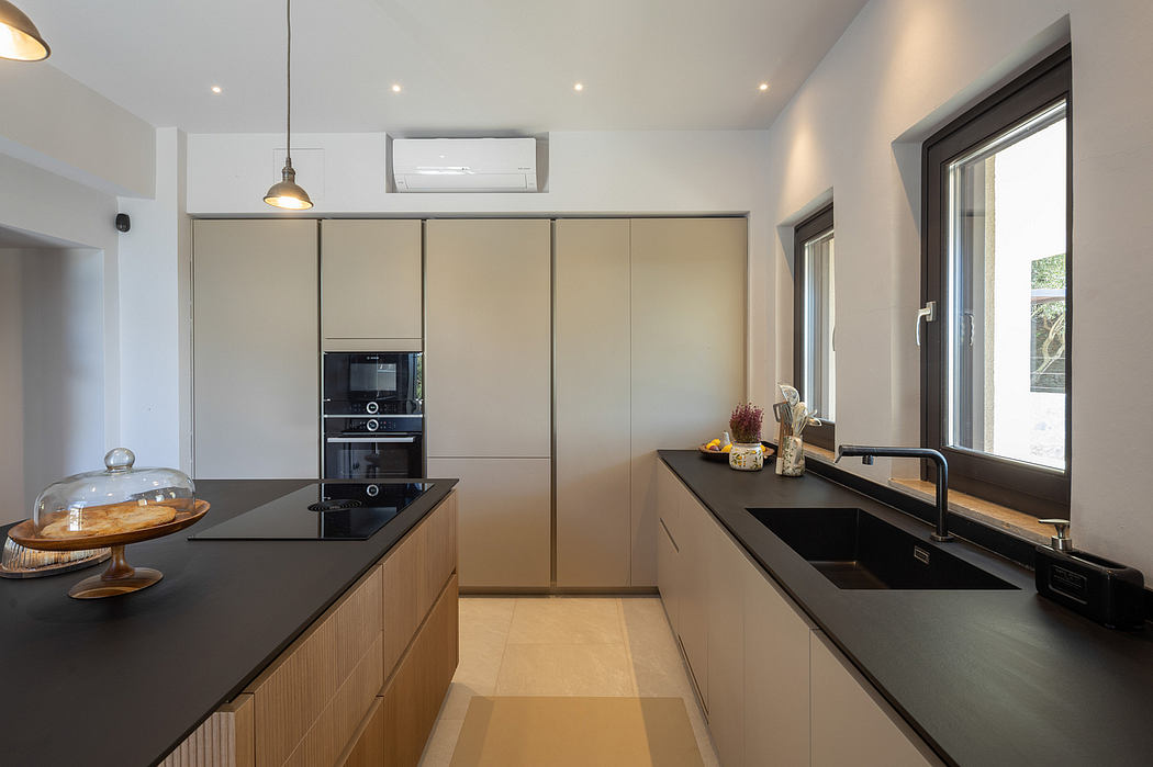 Modern, sleek kitchen with built-in appliances, dark countertops, and light-colored cabinetry.