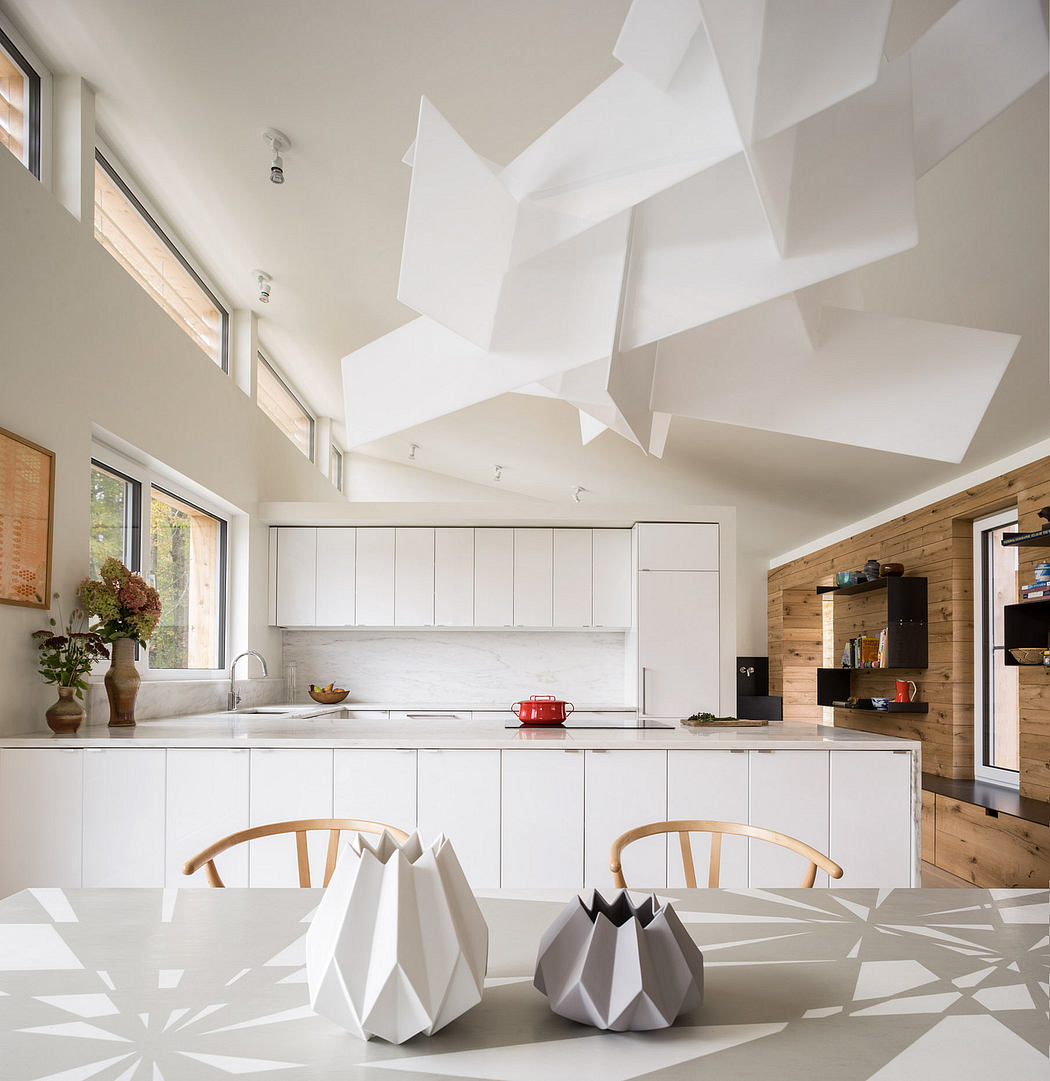 Modern kitchen with sculptural white geometric elements, wooden accents, and expansive windows.