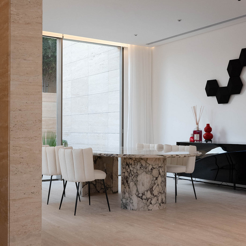 Sleek, modern dining area with marble-top table, minimalist chairs, and striking architectural elements.