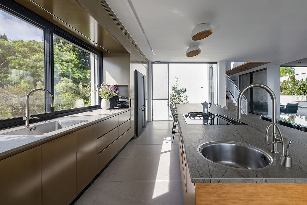 Modern kitchen with sleek cabinetry, large windows, and a striking marble countertop.