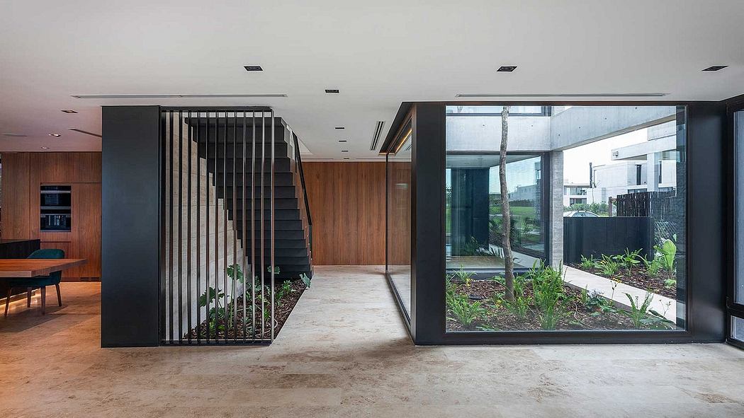 Sleek, modern interior with wooden accents, large glass windows, and geometric staircase.