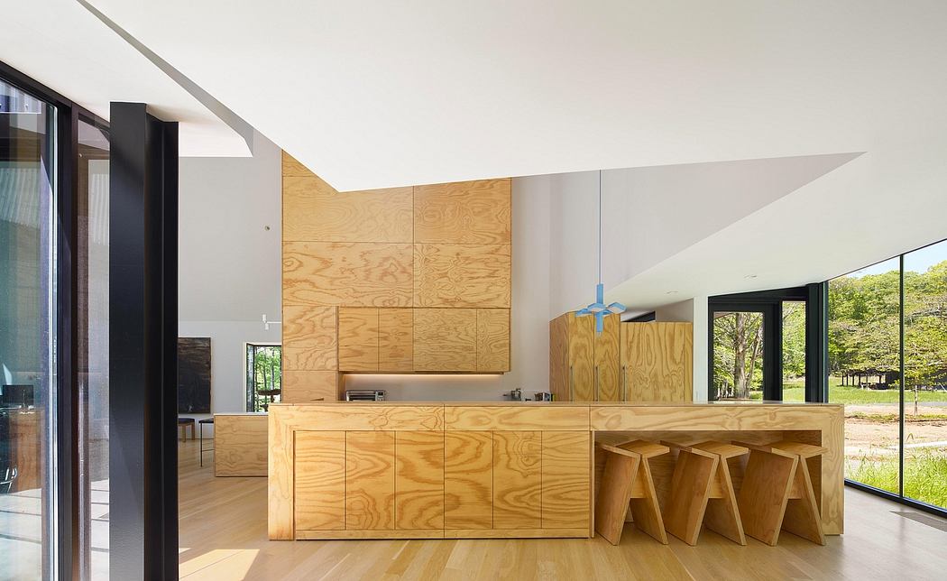 A sleek, modern kitchen with a large wooden island and minimalist cabinetry.
