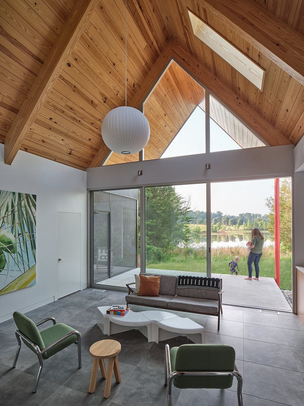 Bright, modern living space with vaulted wooden ceiling, large windows, and minimalist furnishings.