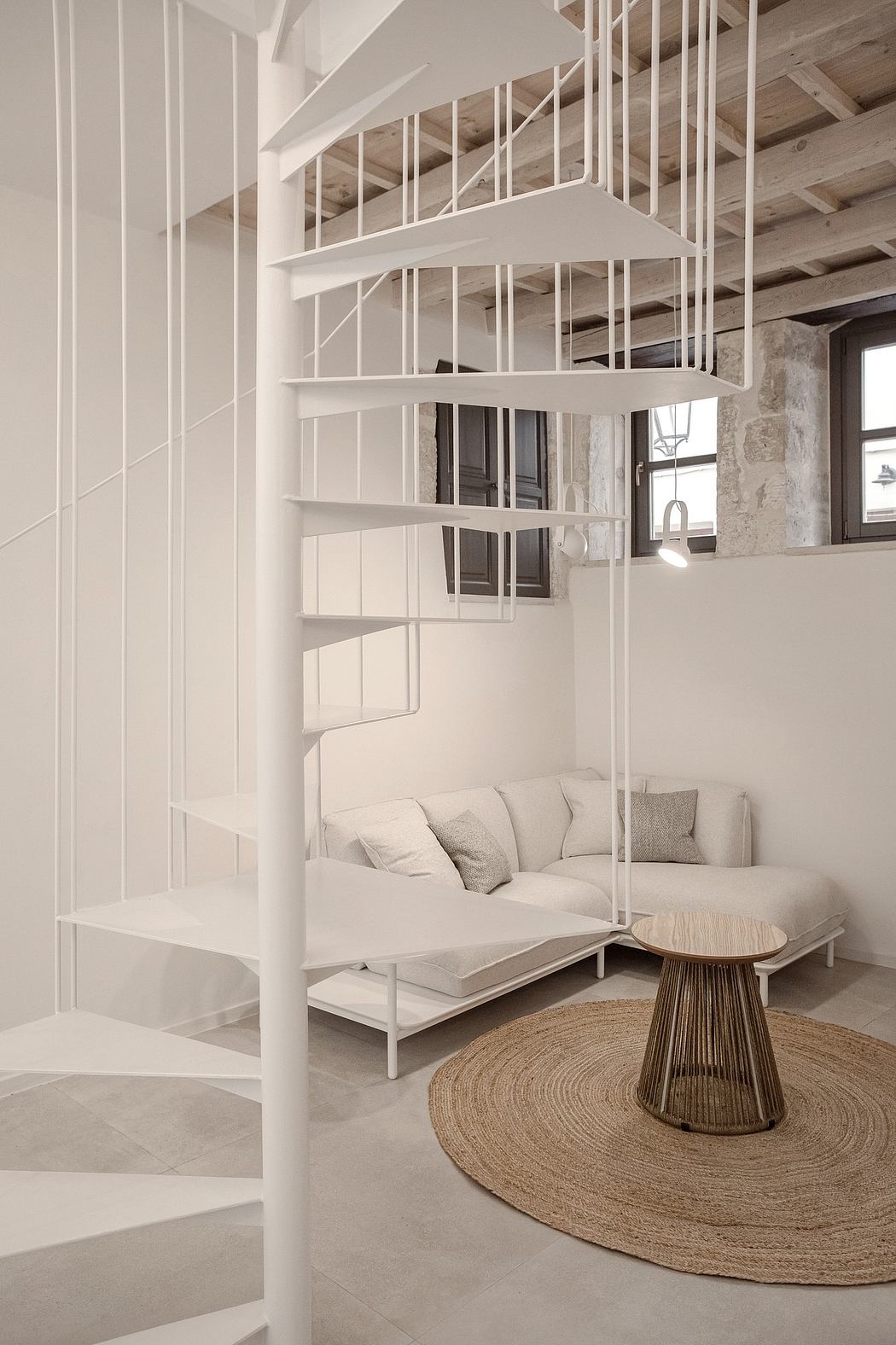 A modern open-plan living space with a spiral staircase, minimalist furniture, and natural decor.