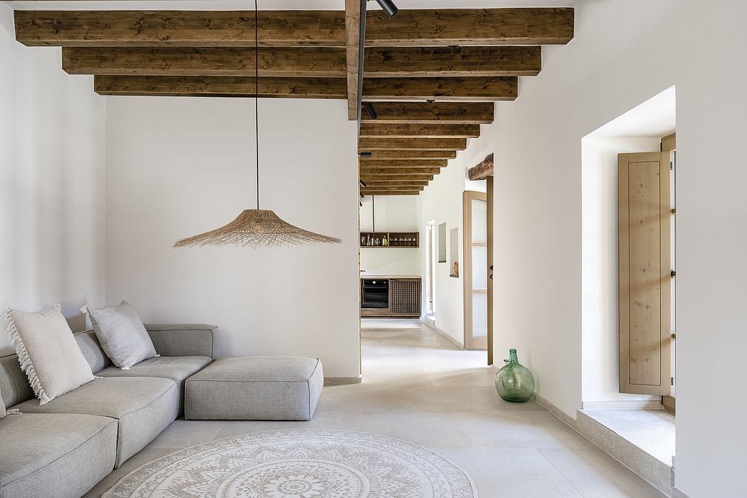 Modern farmhouse interior with exposed wooden beams, neutral palette, and woven light fixture.