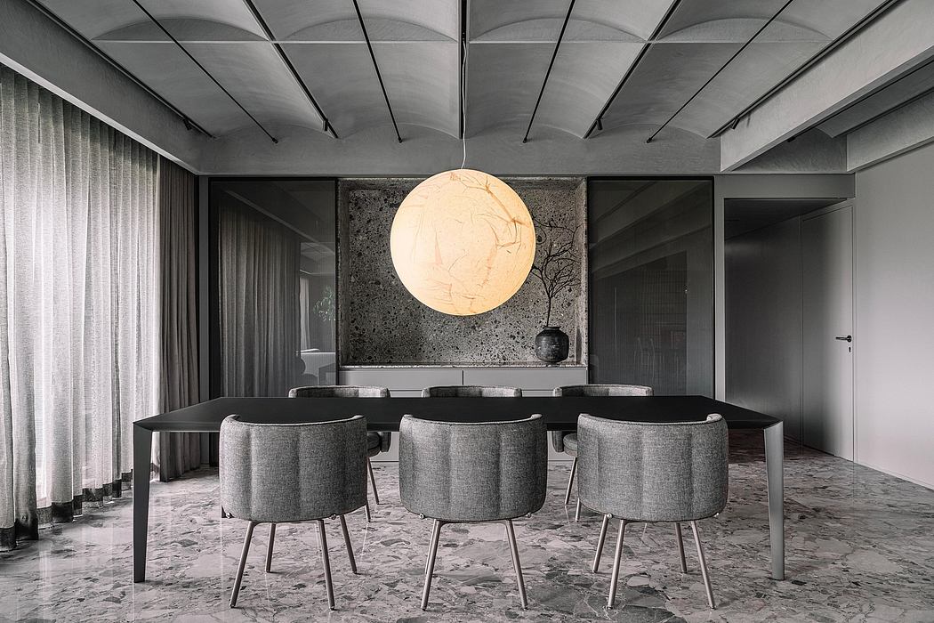 Minimalist dining room with a large, round pendant light, marble floor, and textured wall panels.