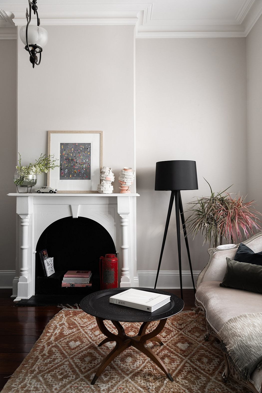 Minimalist living room with fireplace, vintage rug, and modern decor elements.
