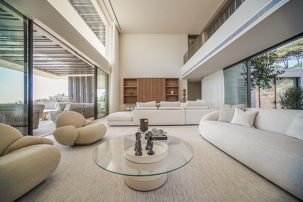 Expansive open-concept living space with plush white furniture, wood accents, and glass walls.