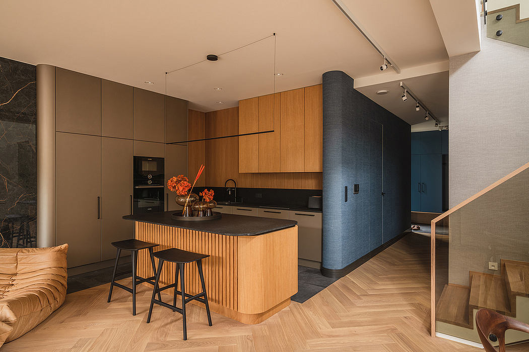 Warm-toned modern kitchen with curved wood cabinetry, black accents, and herringbone flooring.